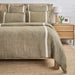 moss and flax textured duvet set on a bed with a wooden headboard and nightstand in a bedroom setting.