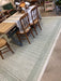 Striped rug on a floor with wooden furniture in the background