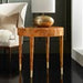 Wooden side table with brass feet and lamp in a room setting