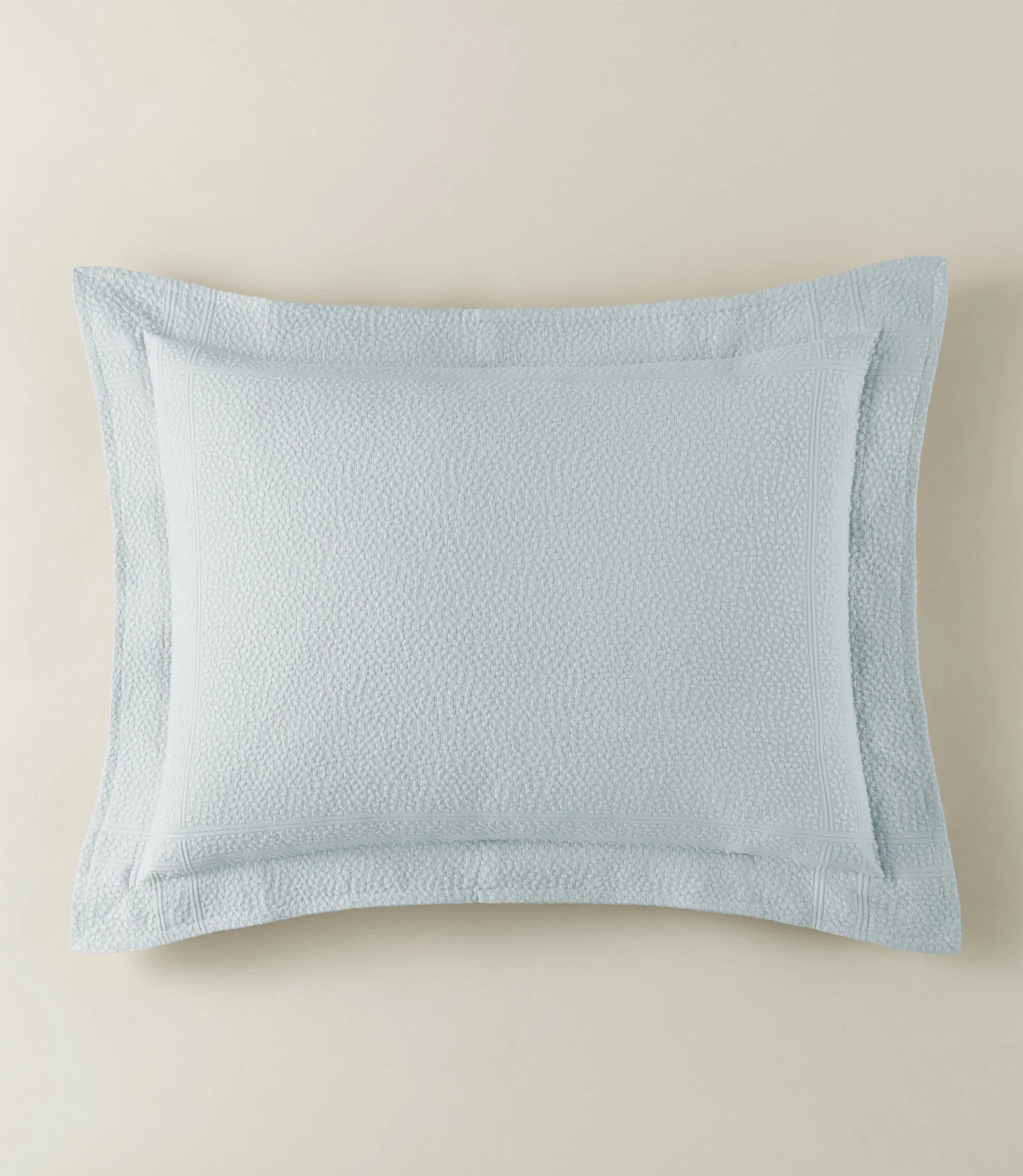 Light blue textured pillow on a beige background