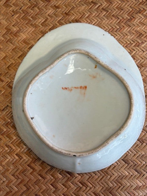 Bottom of a ceramic plate with brownish edge on a woven surface