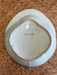 Bottom of a ceramic plate with brownish edge on a woven surface