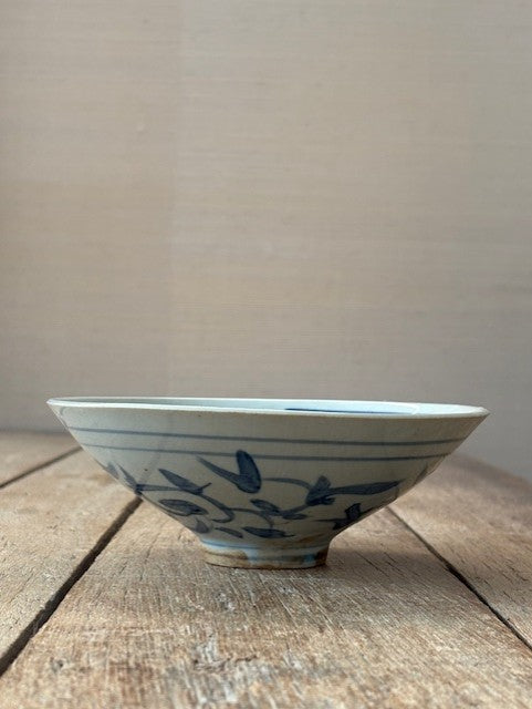 Ceramic bowl with blue floral patterns on a wooden surface