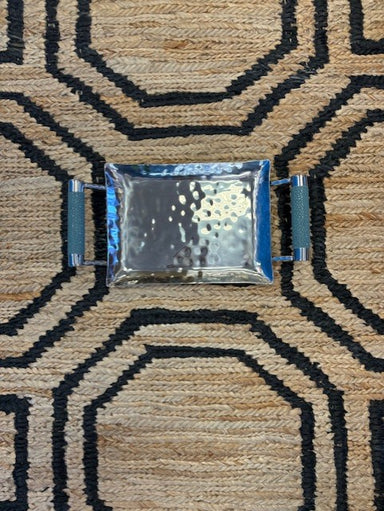 Small rectangular tray with blue frame on a textured brown and black patterned surface