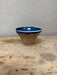 Ceramic bowl with blue interior on a wooden surface