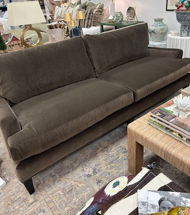 Brown sofa in a living room setting with a coffee table and decorative items.