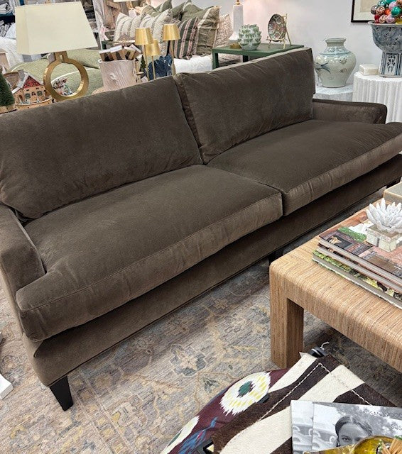 Brown sofa in a living room setting with a coffee table and decorative items.