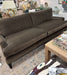 Brown sofa in a living room setting with a coffee table and decorative items.