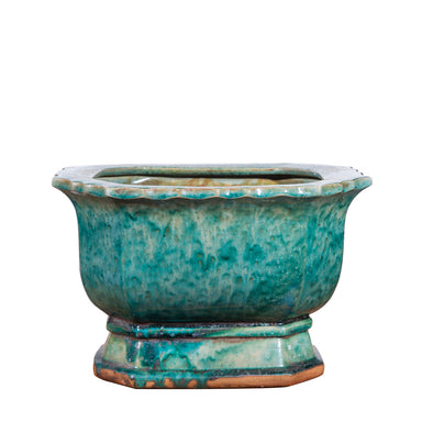 Teal ceramic planter on a white background