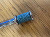 Blue textured handle with silver accents on a wooden surface