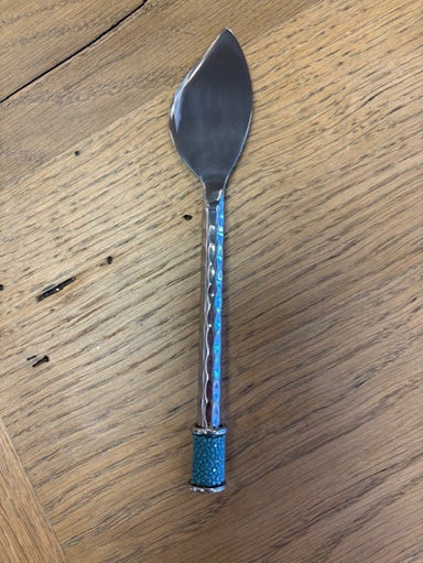 Spreader with a decorative blue handle on a wooden surface