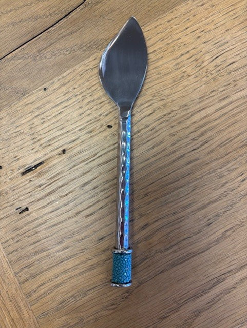 Spreader with a decorative blue handle on a wooden surface