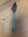 Spreader with a decorative blue handle on a wooden surface