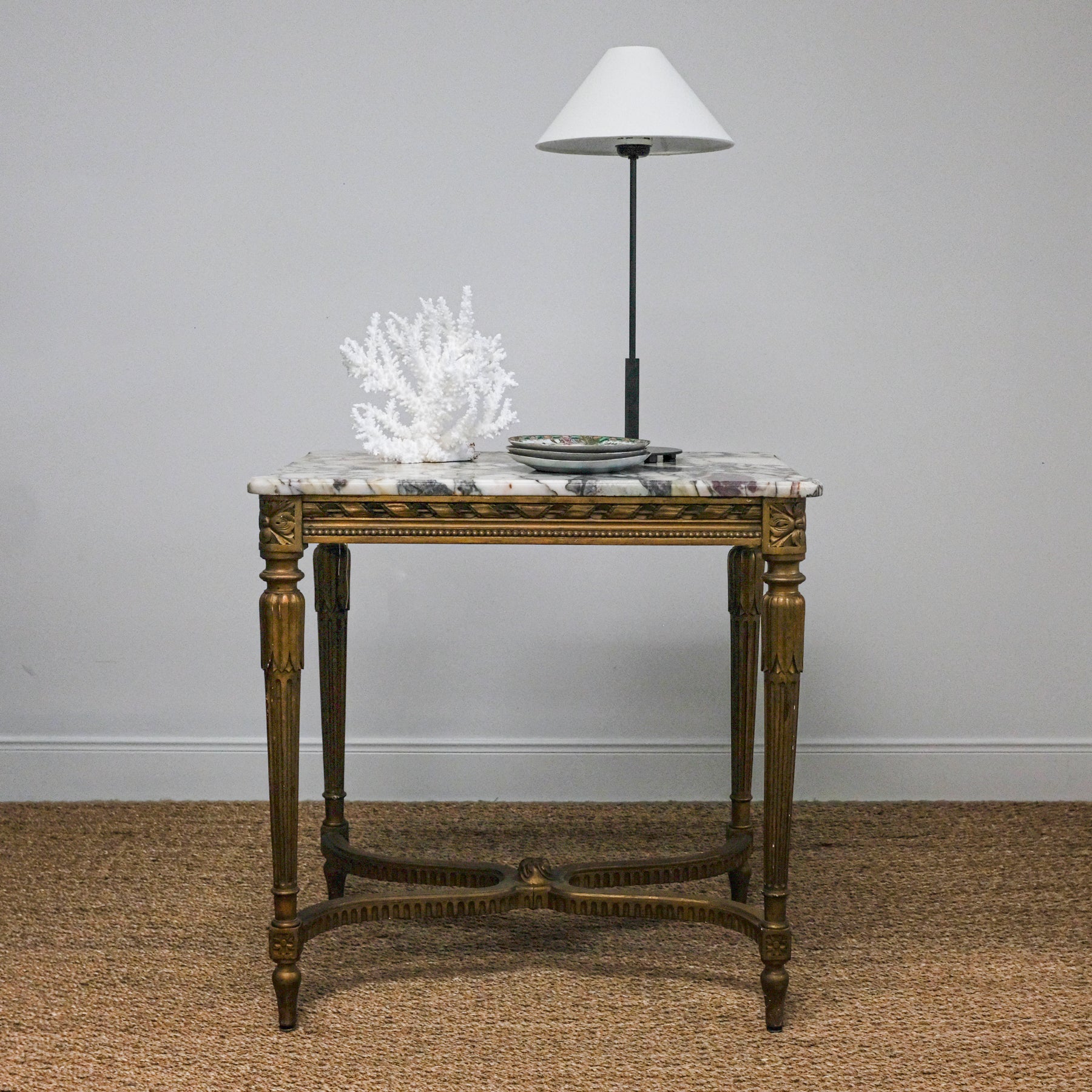 marble-top antique table set with lamp and white coral