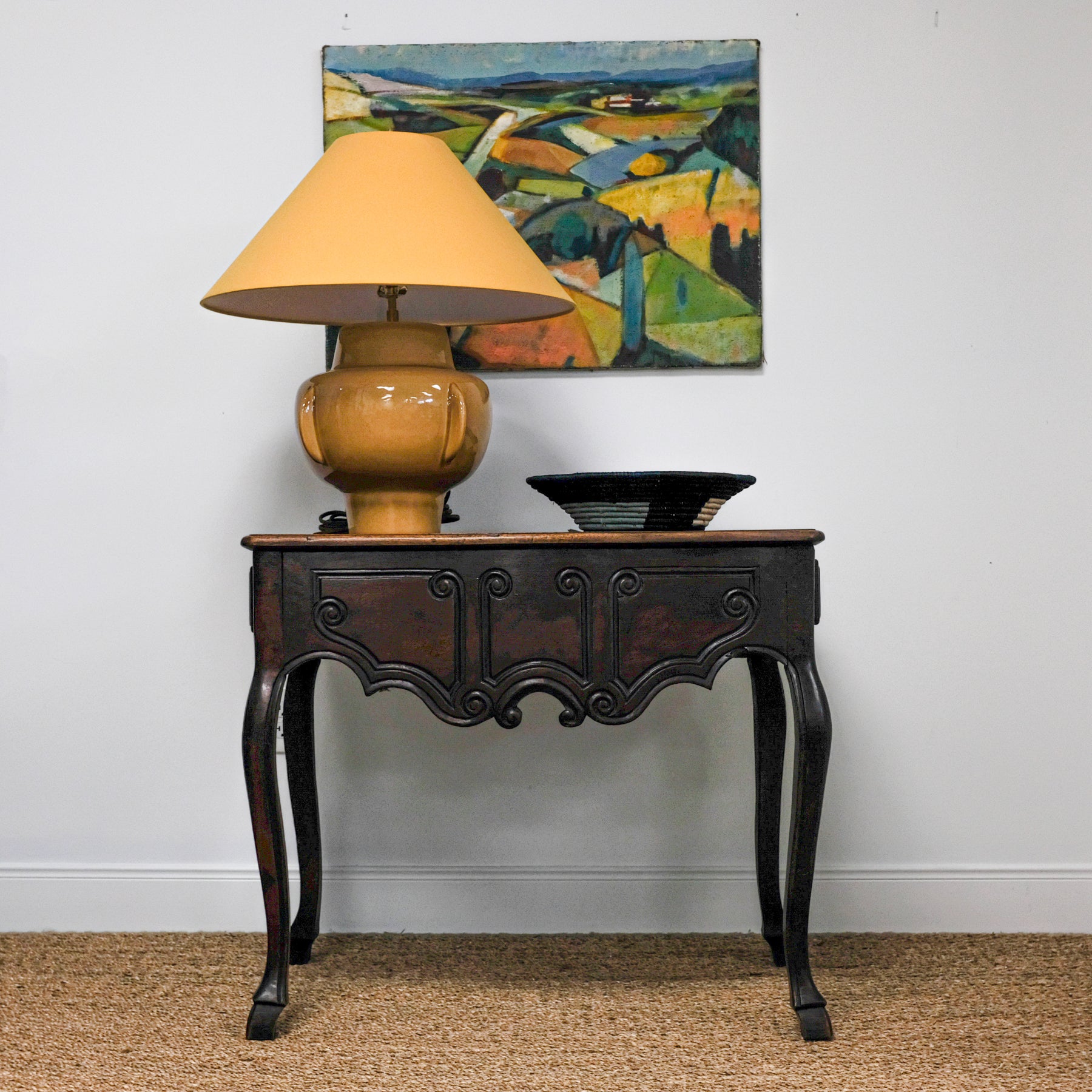 antique table with yellow lamp and artwork