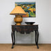 antique table with yellow lamp and artwork