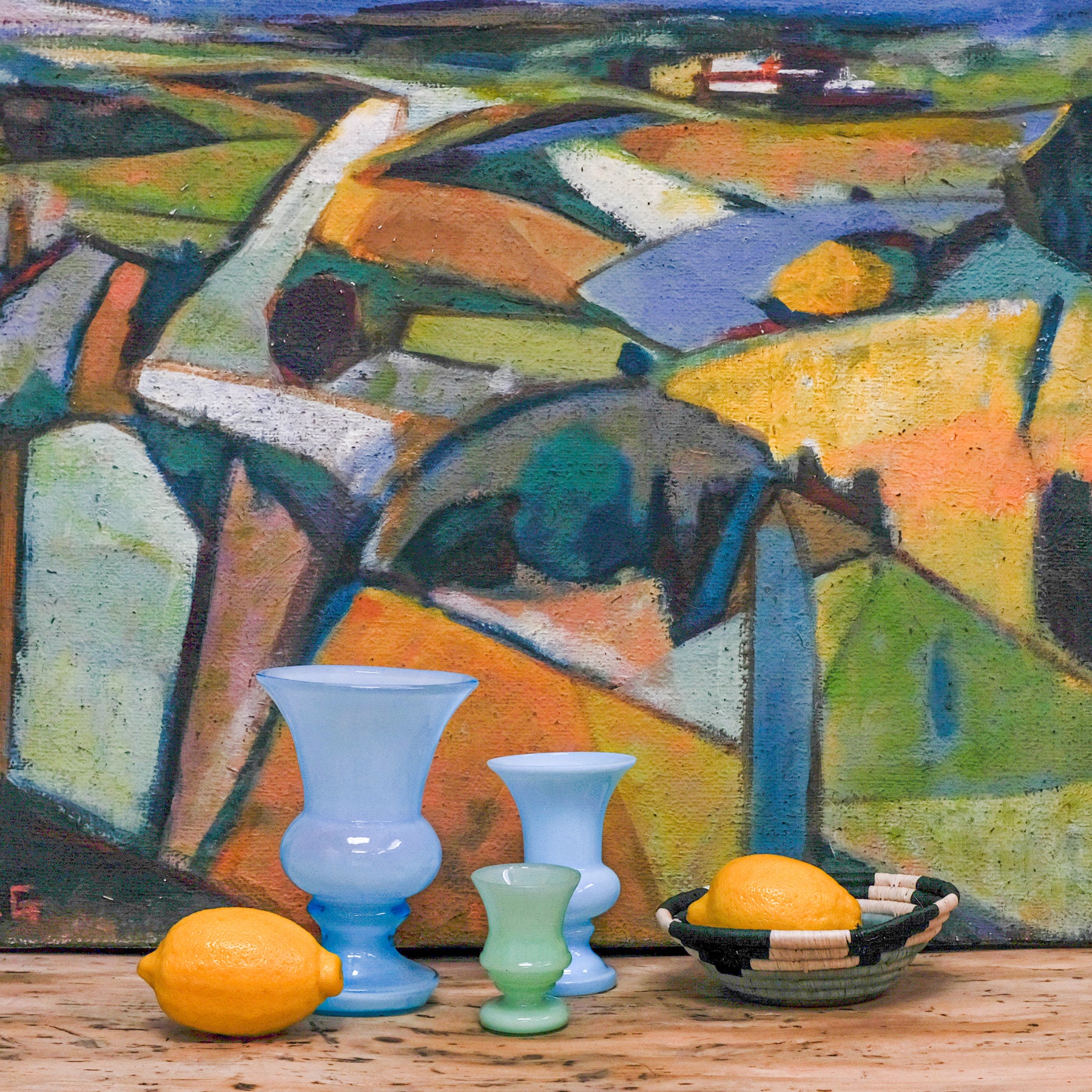 trio of glass vases in front of abstract landscape