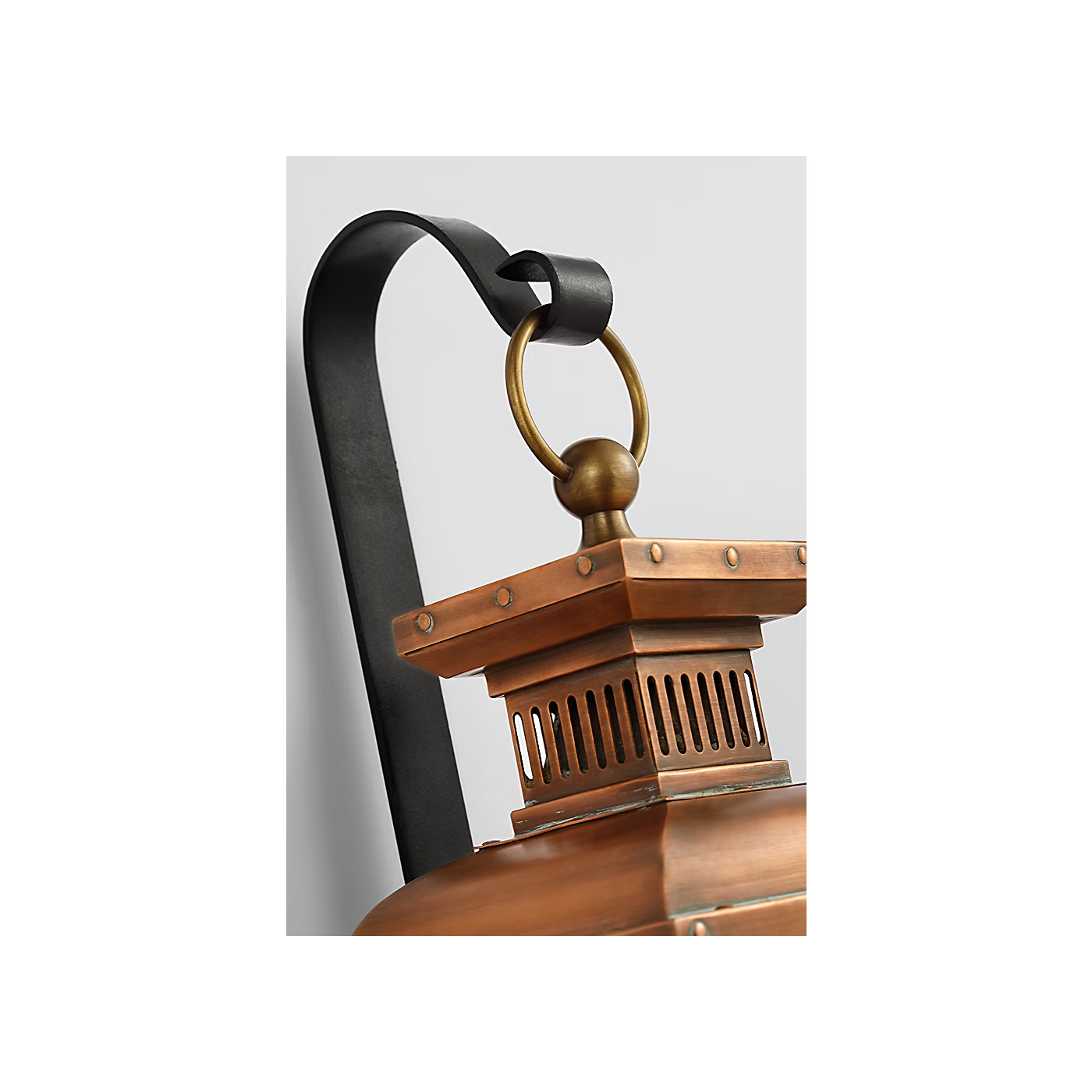 Close-up of a copper lantern with a black handle on a white background