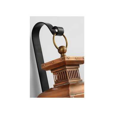 Close-up of a copper lantern with a black handle on a white background