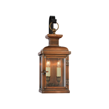Vintage-style copper lantern with two lit candles on a white background