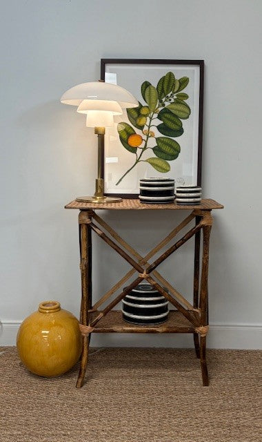 Small wooden side table with decorative items against a plain wall