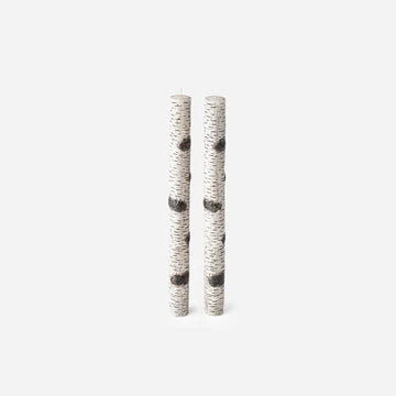 Two pillar candles with birch textured surfaces on a white background