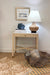 Nautical-themed room with a side table, lamp, and decorative items.