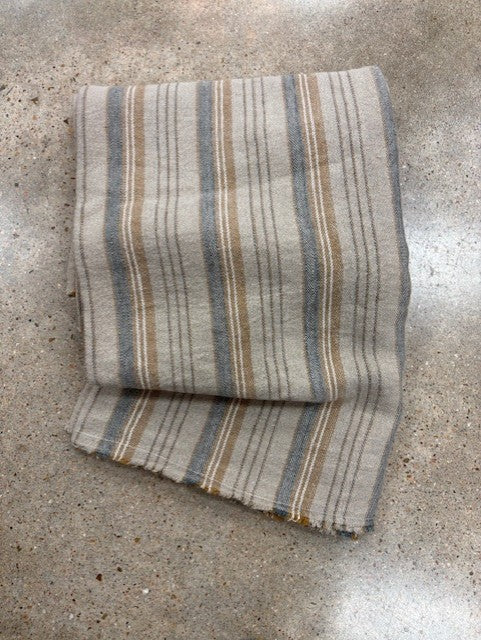 Folded striped throw on a concrete surface