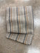 Folded striped throw on a concrete surface