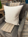 Gray cushioned chair with a white pillow and striped throw