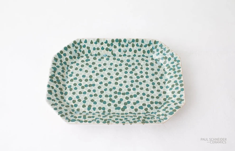 Rectangular ceramic plate with green dot pattern on a white background