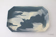 Marbled ceramic tray with dark and light blue patterns on a white background
