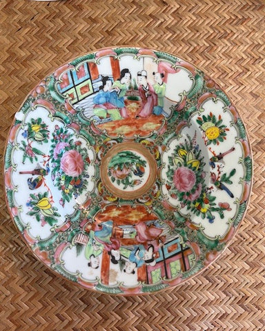 Decorative ceramic plate with colorful designs on a woven surface