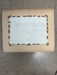 Rectangular object with a white center and brown border on a gray surface