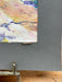 Artistic watercolor painting on a gray background with a signature