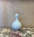 White ceramic bottle on a marble surface with a textured wall background