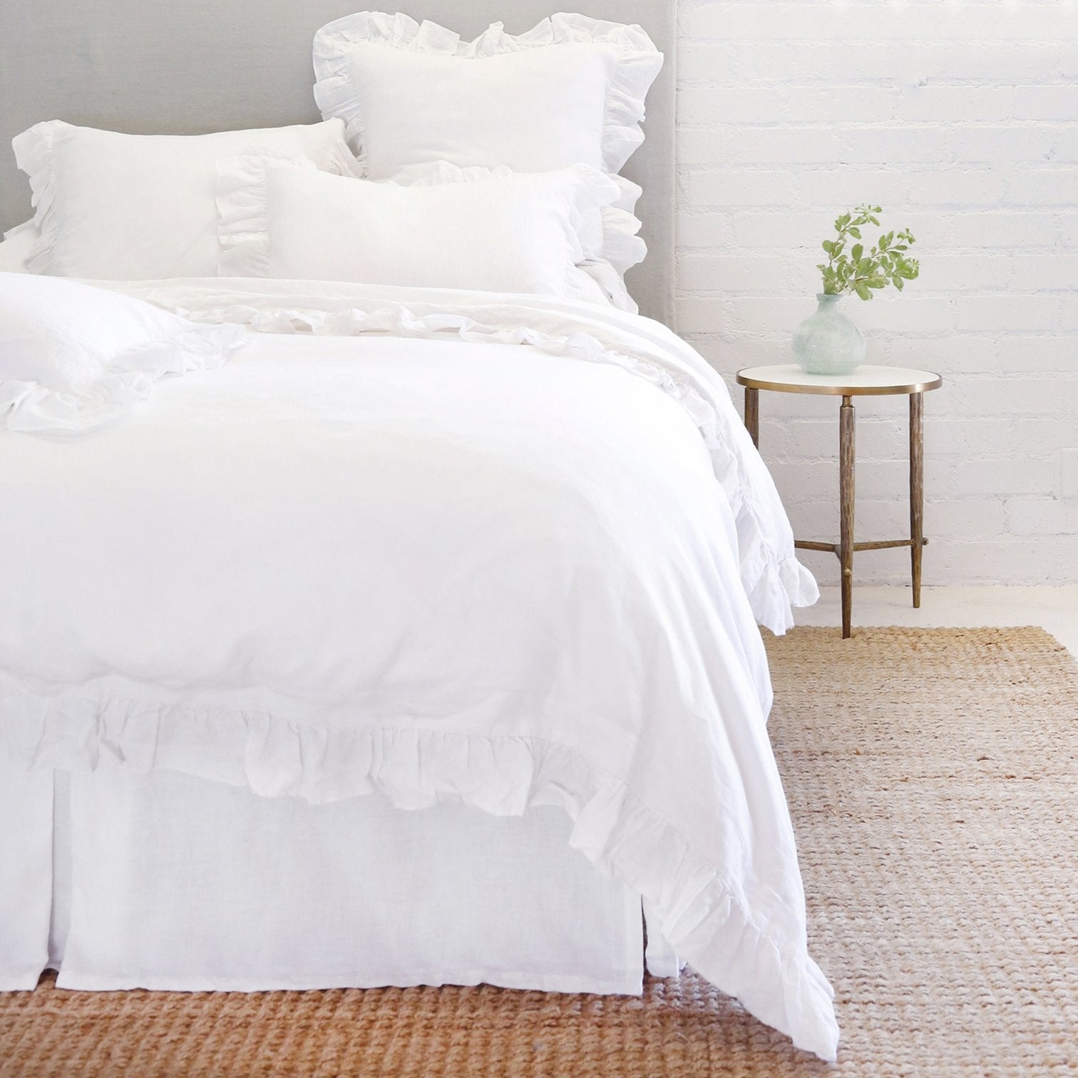 white linen bedding with ruffle on bed