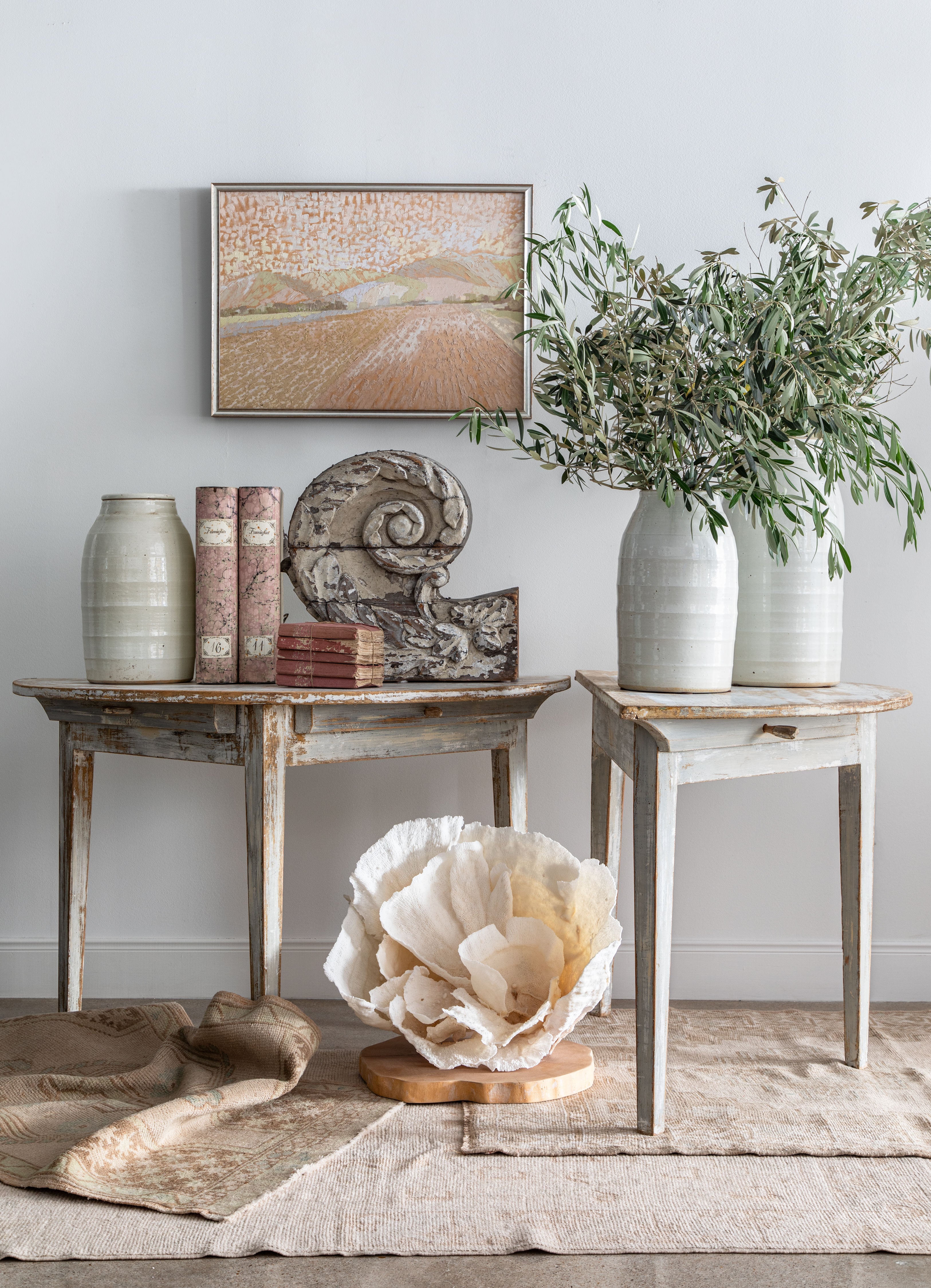 creative display with antique wood fragment, coral, oil painting and olive branches on two demilunes