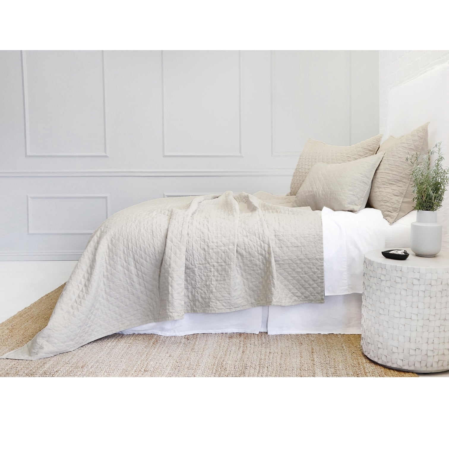 side view of bed dressed with linen bedding