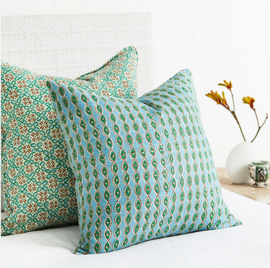 blue, green and brown pillows on a bed