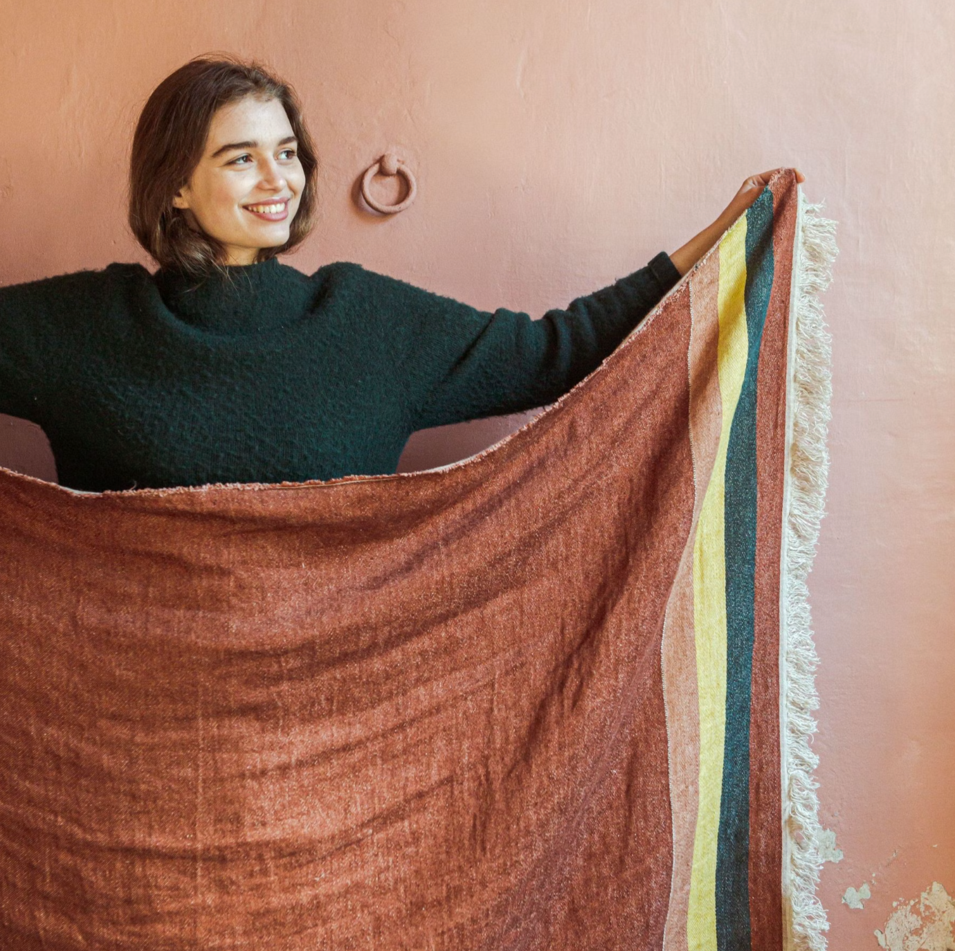 woman holding a Belgian linen towel to show color and design
