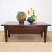 dark wood coffee table with pottery