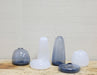 collection of white and blue glass vases in various shapes