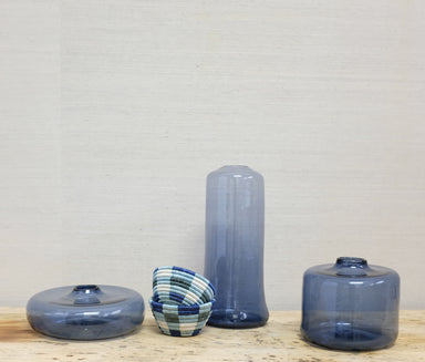 woven blue baskets among several transparent blue glass vases