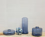 woven blue baskets among several transparent blue glass vases