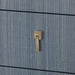 brass pull detail on blue grasscloth-covered chest of drawers