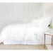 side view of white linen duvet cover with ruffle on bed