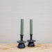 sage green candles in black pottery holders