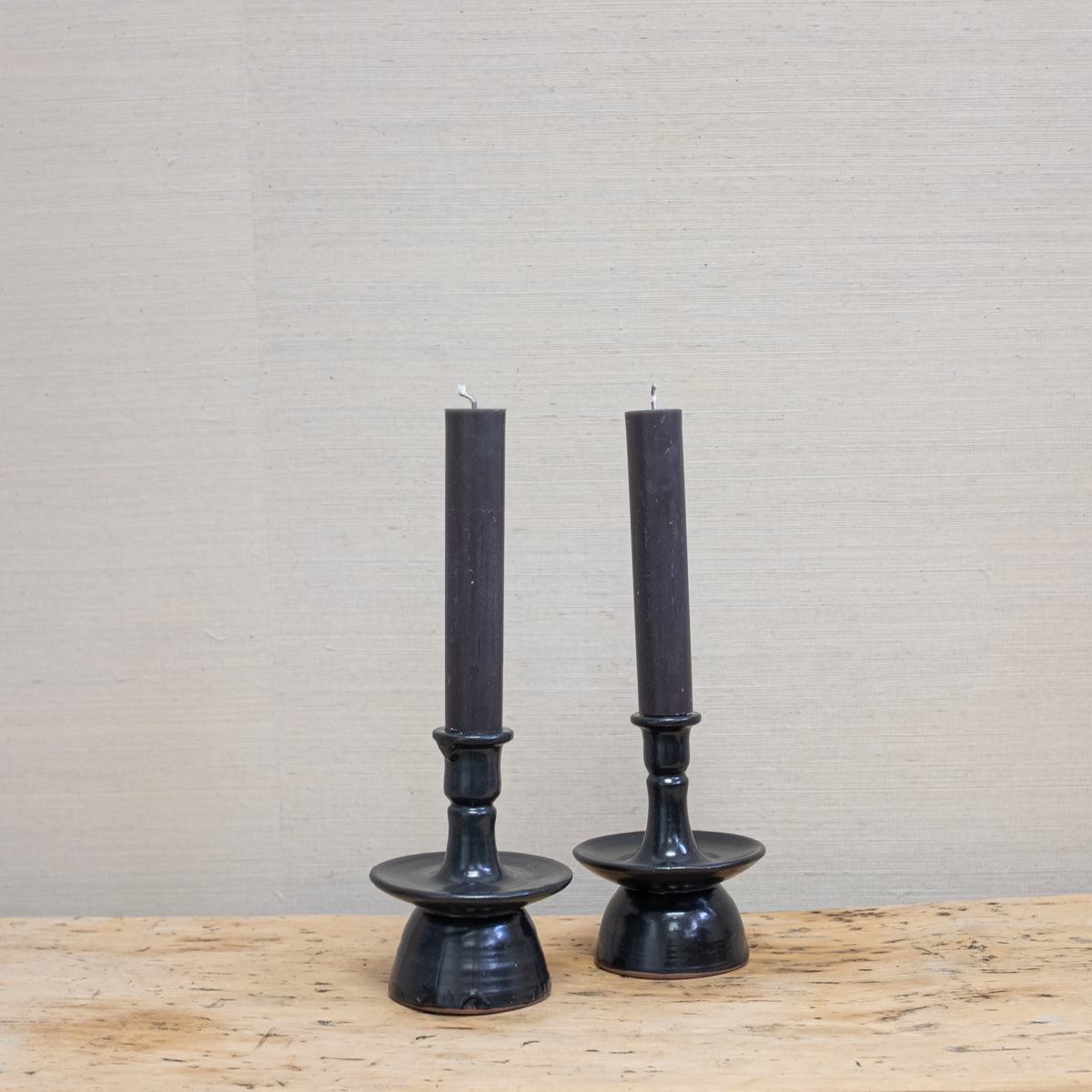 green-black candles in black pottery candleholders