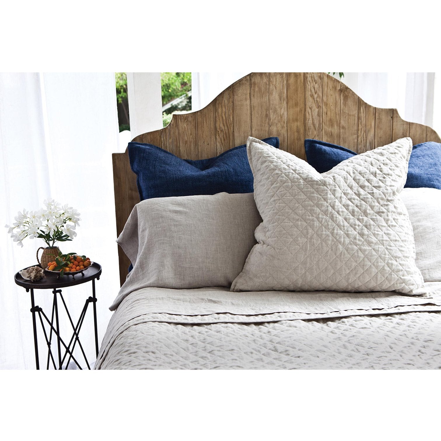 diamond quilted grand euro sham with linen pillowcases and dark blue euro shams, wood headboard